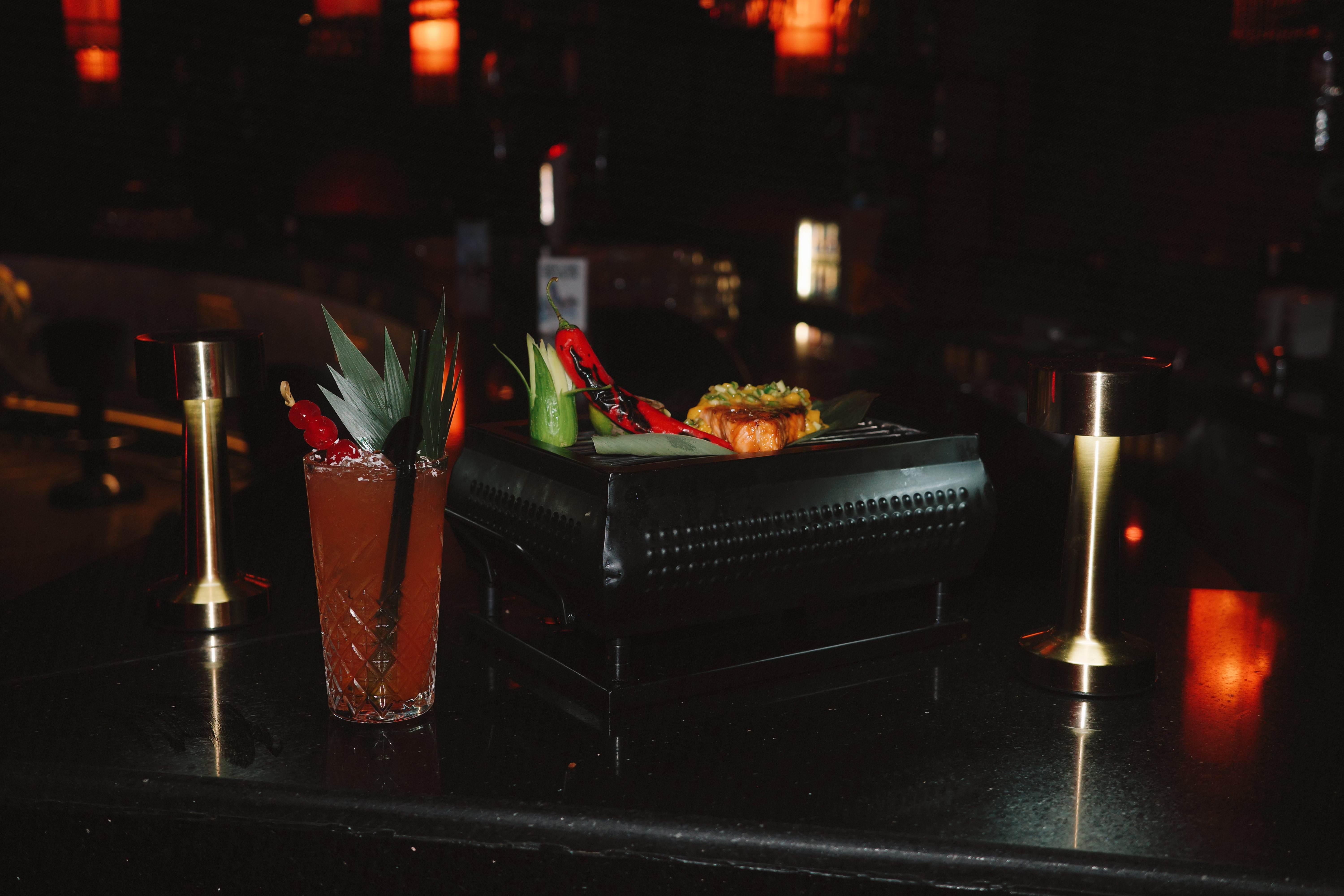 Signature cocktail and sushi presentation with candles