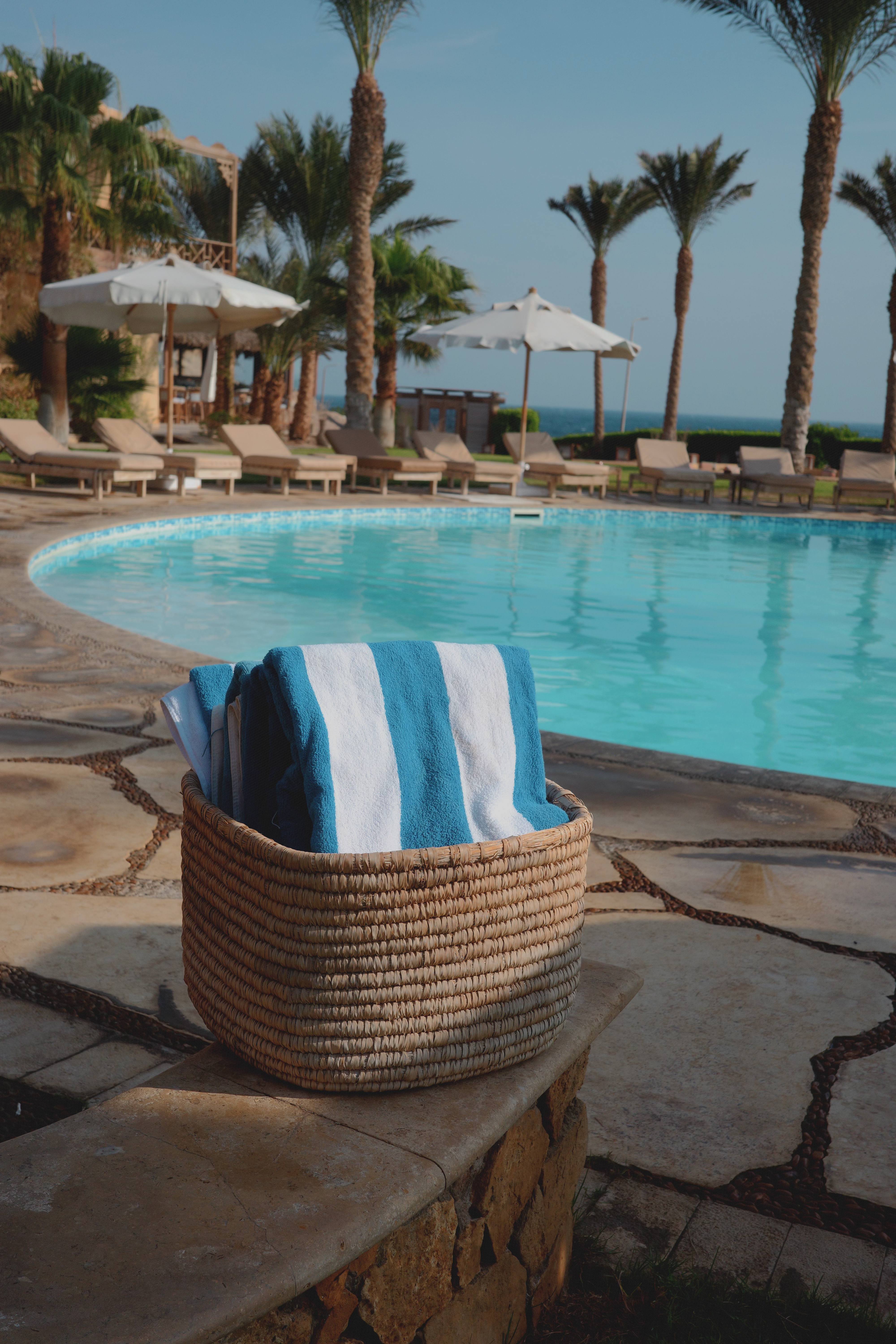 Striped towels in basket by the pool