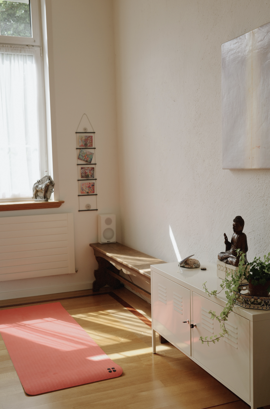 Yoga studio interior with pink mat and Buddha statue