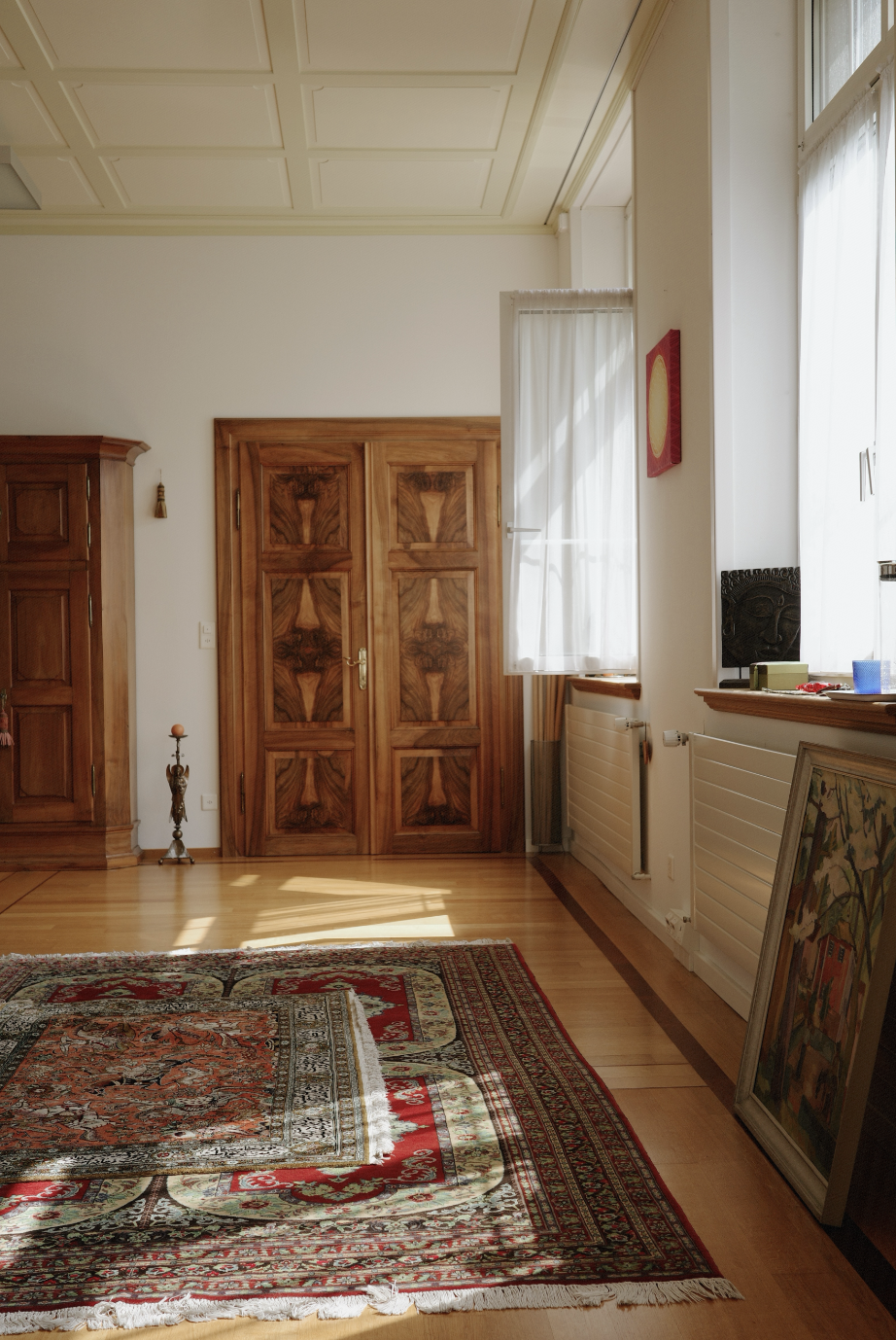 Spacious yoga studio with wooden floors and ornate doors