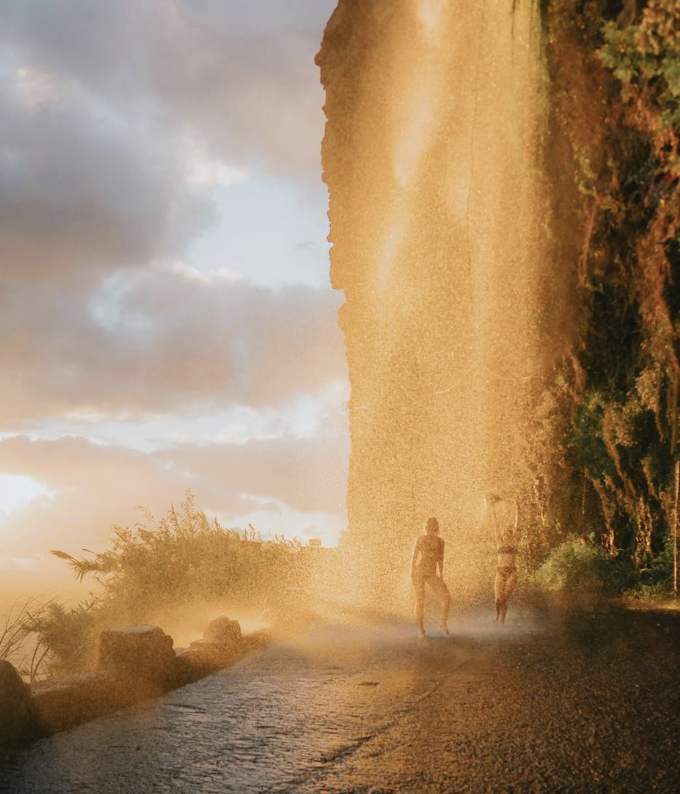 Silhouettes at waterfall during golden hour